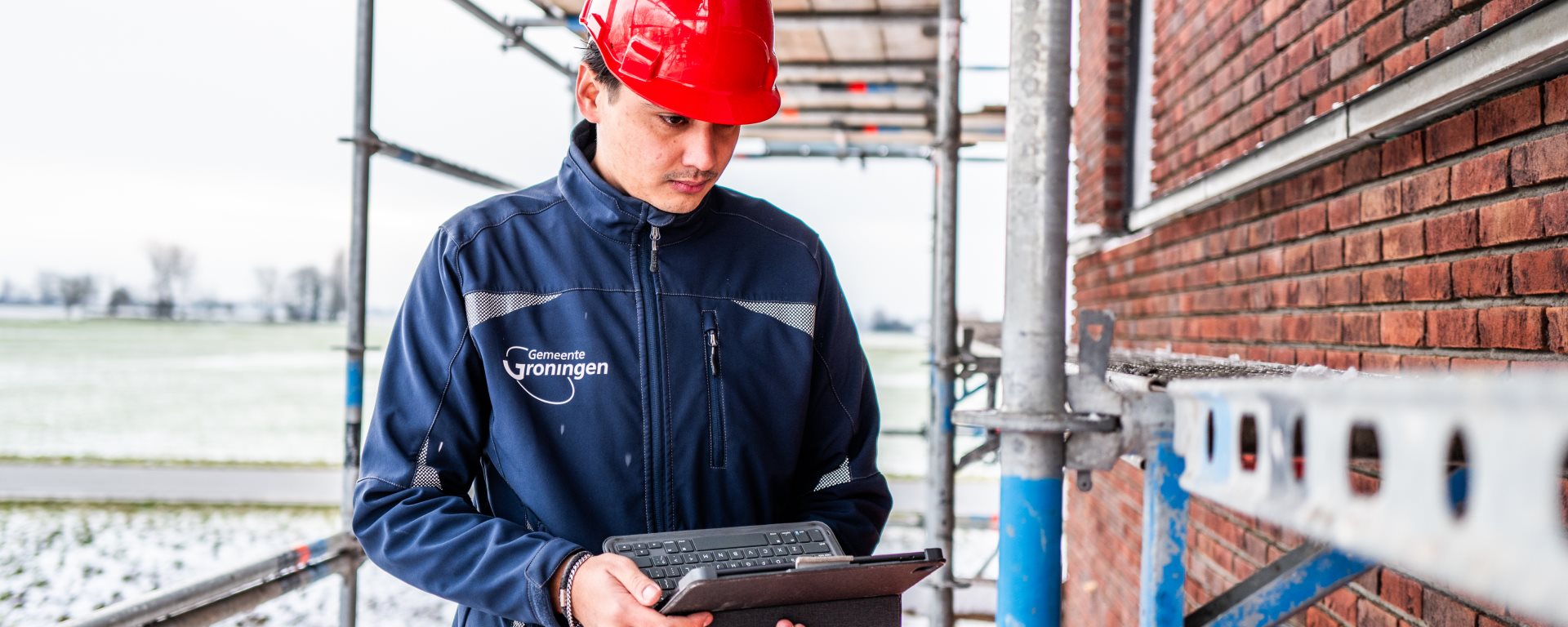 Bouwinspecteur op een stijger met een tablet in zijn handen 2