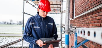 Bouwinspecteur op een stijger met een tablet in zijn handen 2