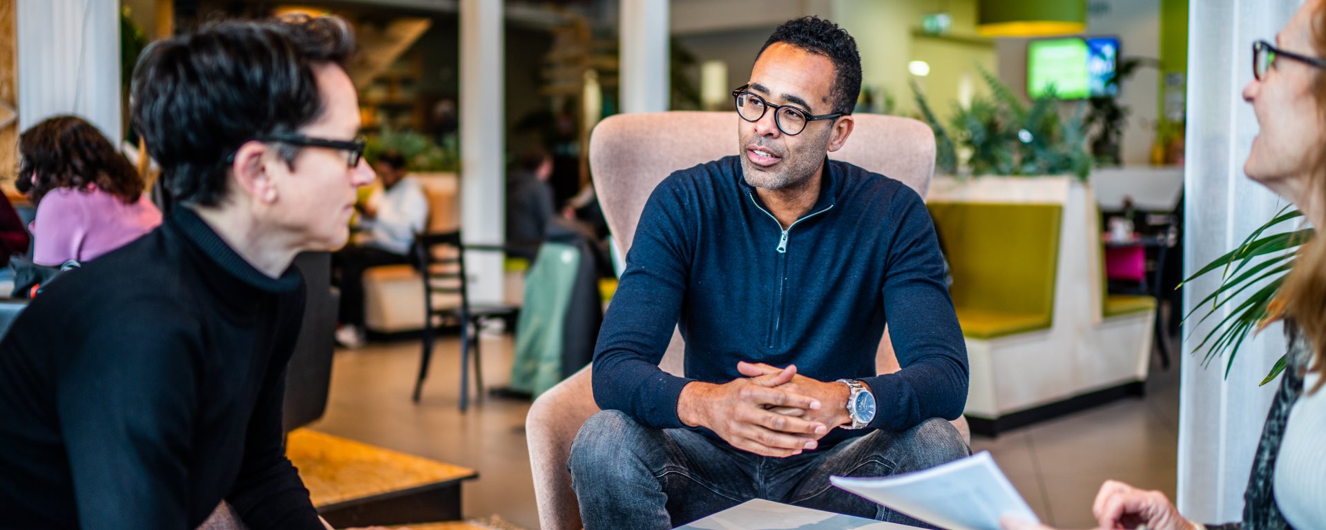Drie collegas met elkaar in gesprek