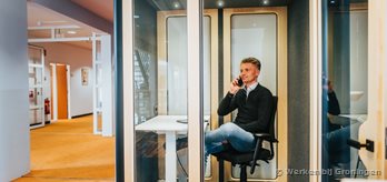 Een medewerker aan de telefoon zittend in een busypod (1)
