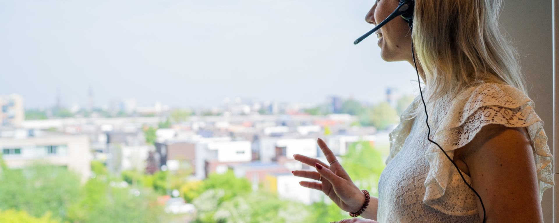 Een medewerker die met een headset op uit het raam kijkt