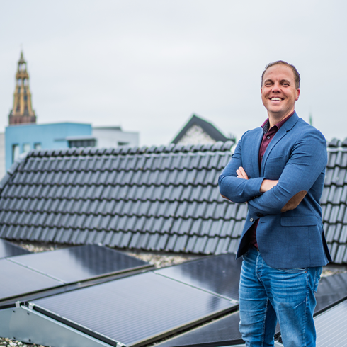 Medewerker Eppie op een dak met zonnepanelen