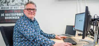 Man achter PC met schermen