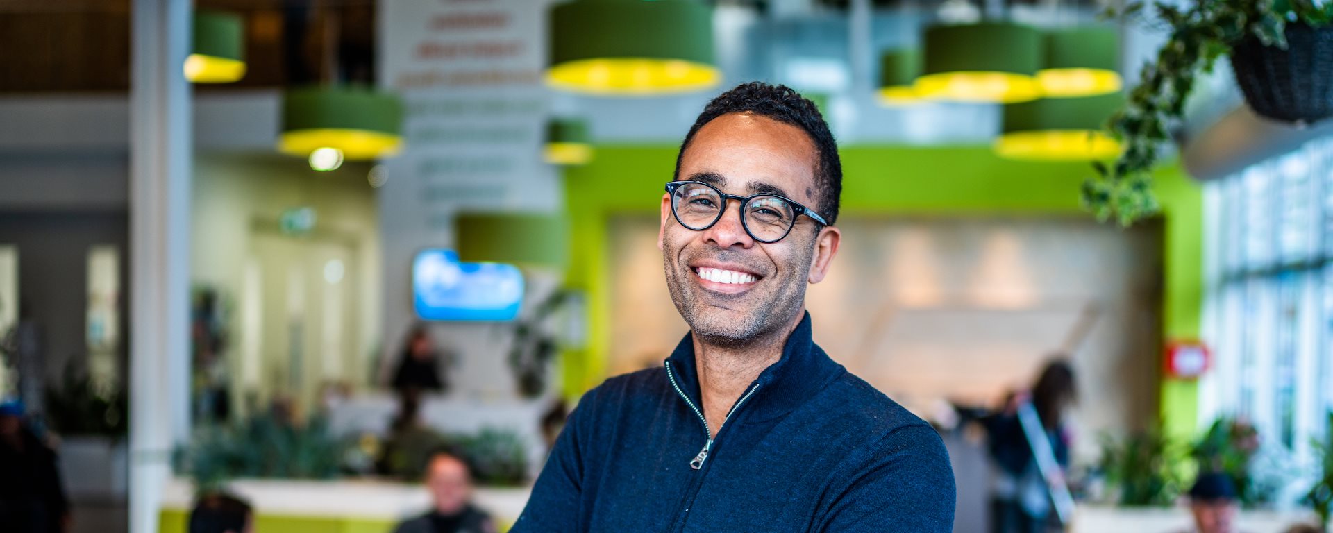 Medewerker Mazanga met een ontvangstruimte op de achtergrond