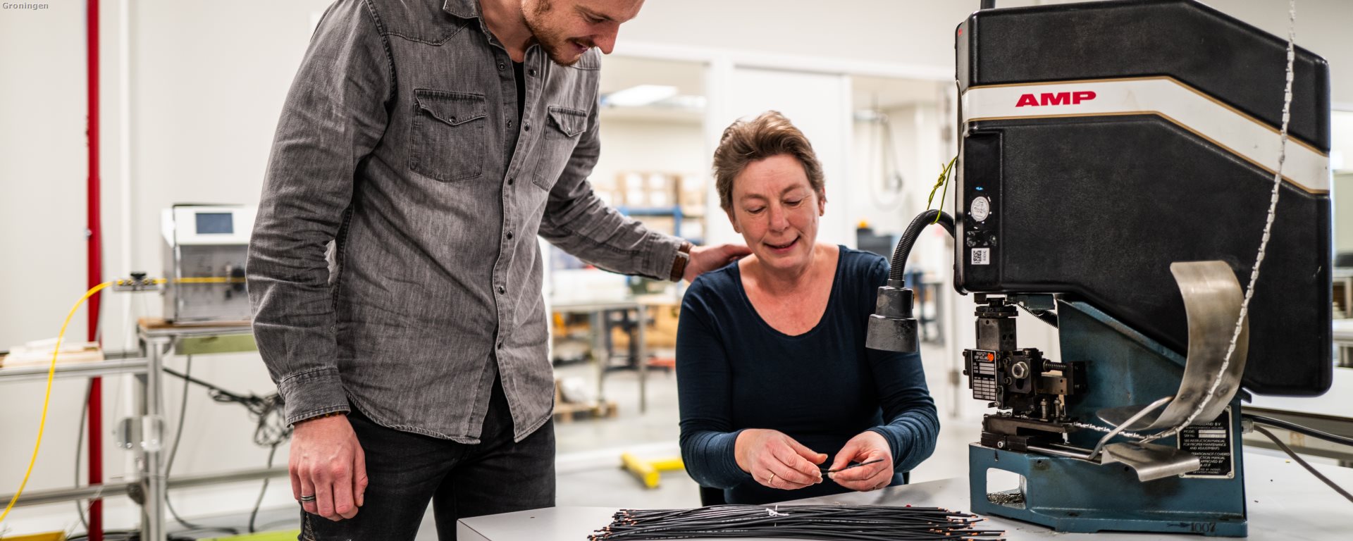 Medewerker helpt bij het bedienen van de apparatuur