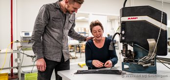 Medewerker helpt bij het bedienen van de apparatuur