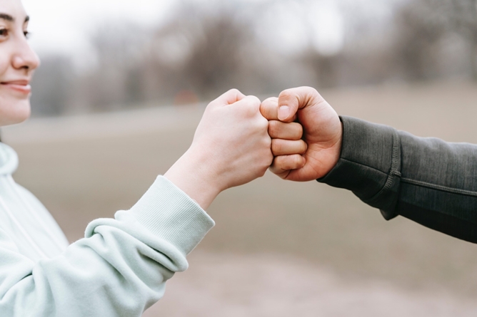 Twee medewerkers die elkaar een boks geven