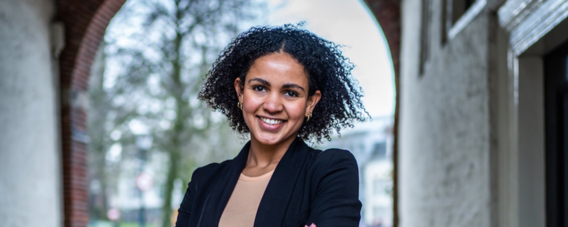 Medewerker Naomi met op de achtergrond een gebouw