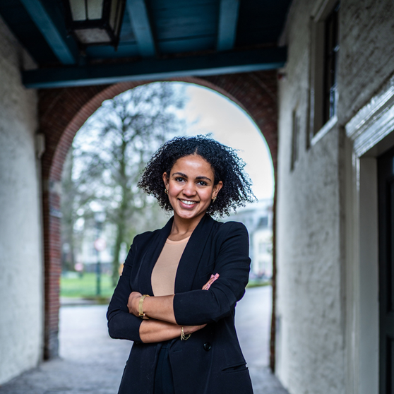 Medewerker Naomi met op de achtergrond een gebouw