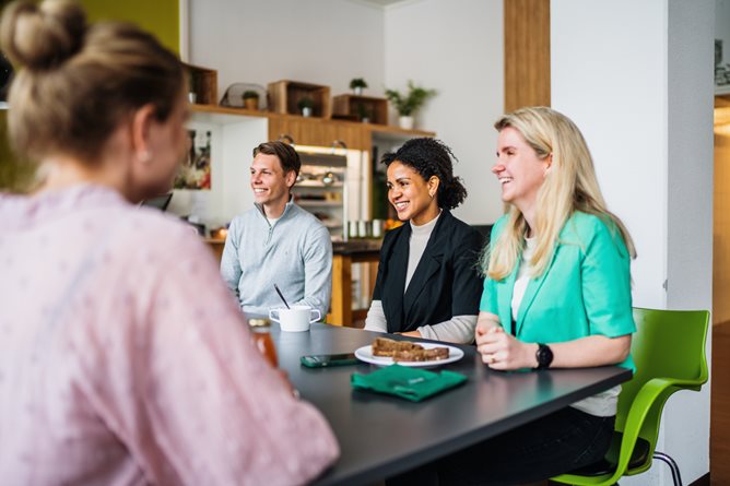 Drie medewerkers op een rij aan de lunchtafel