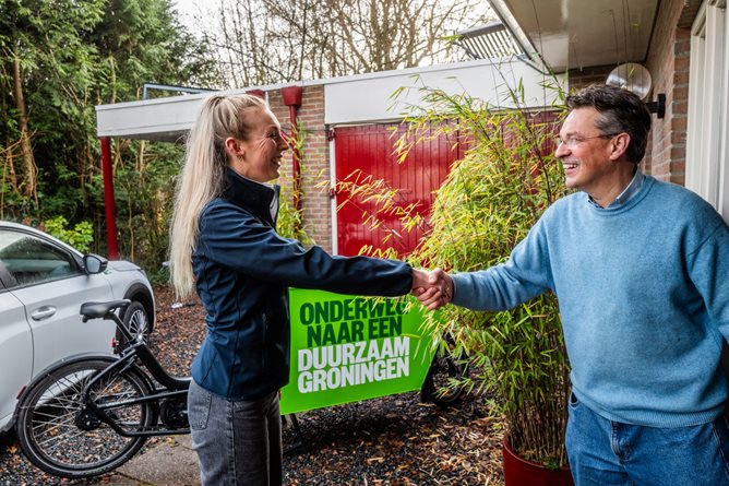Medewerker en inwoner geven elkaar de hand