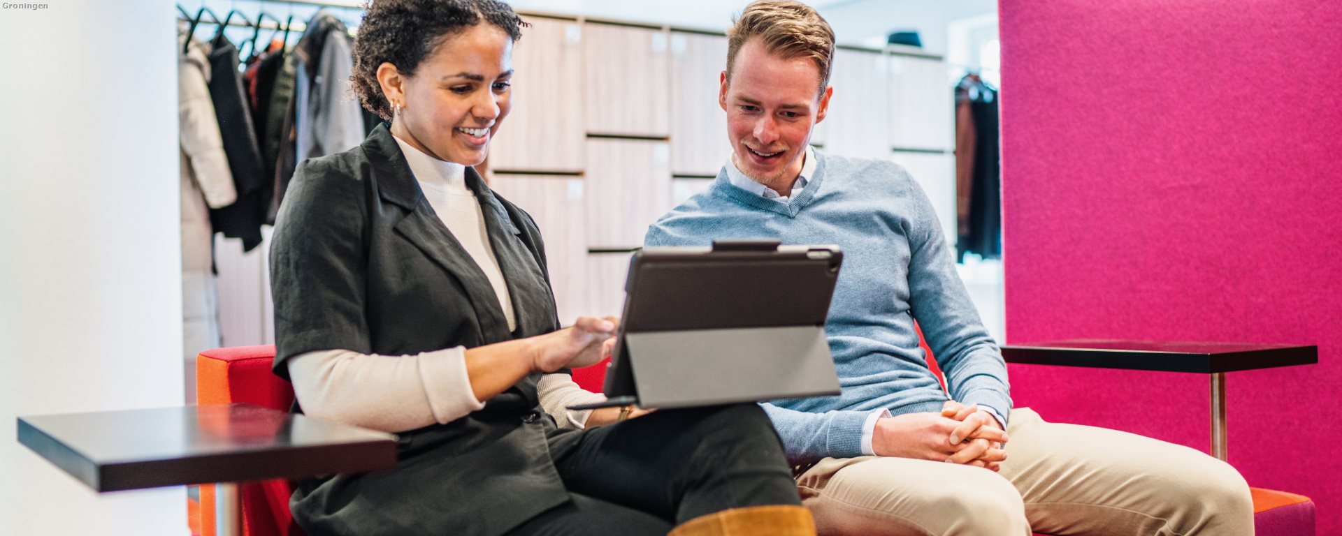 Twee medewerkers kijkend naar een tabletscherm