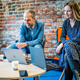 Twee medewerkers kijkend naar laptopschermen