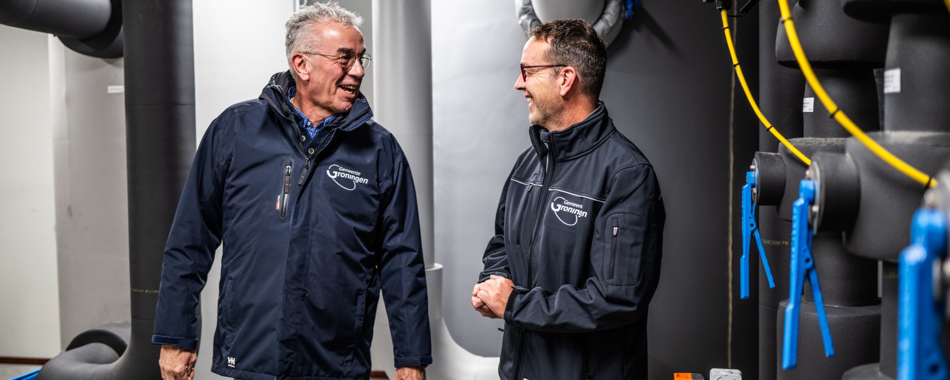 Twee medewerkers praten over de waterinstallatie