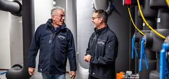 Twee medewerkers praten over de waterinstallatie